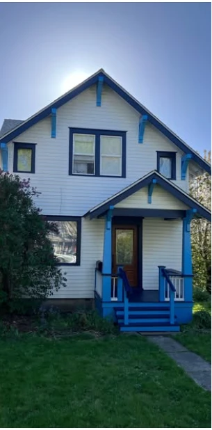 After painting: the same house with stronger blue trim around the roof, windows and porch