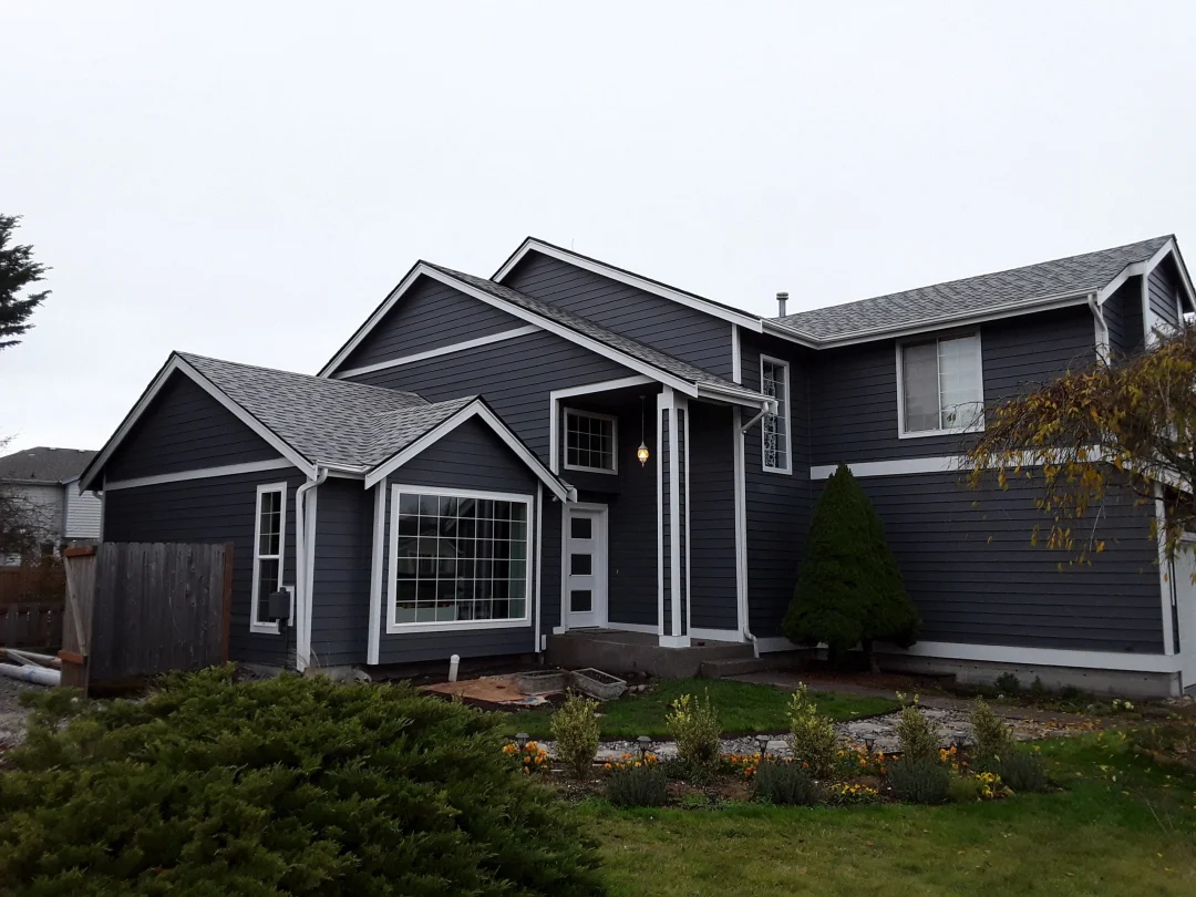 Dark painted siding and white trim on a multi-gabled home in LLN’s published gallery